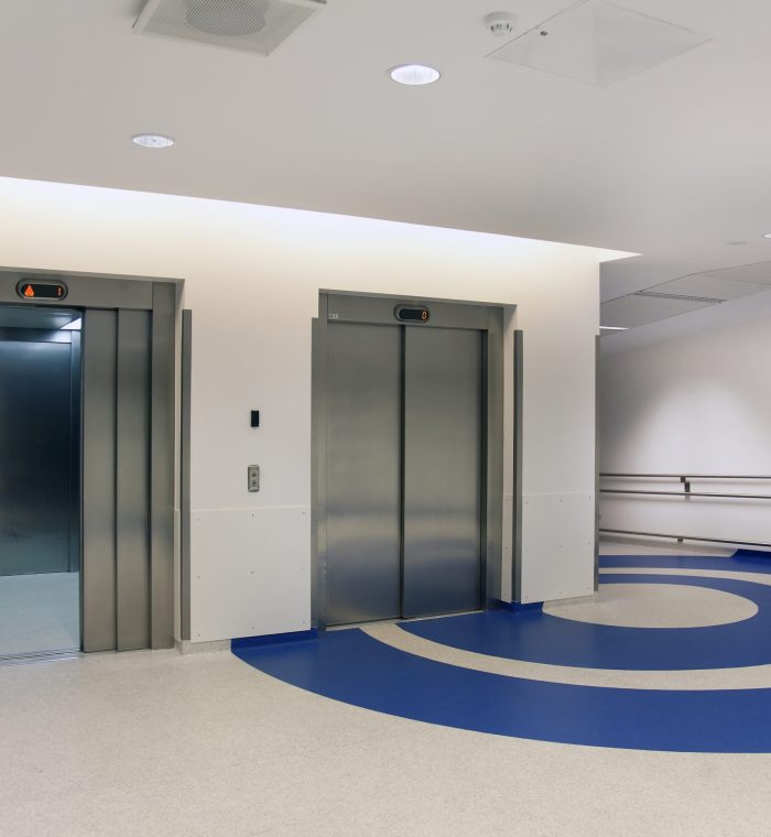 Elevators in the atrium of a new modern hospital, blue patterns on the floor