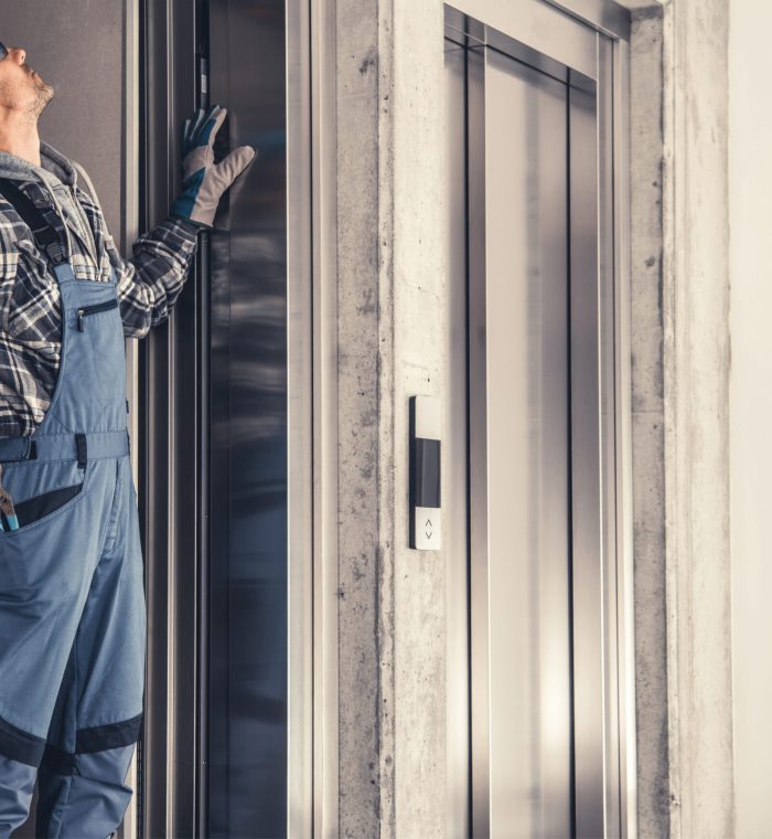 Caucasian Residential Elevator Technician in His 40s Performing Scheduled Maintenance.