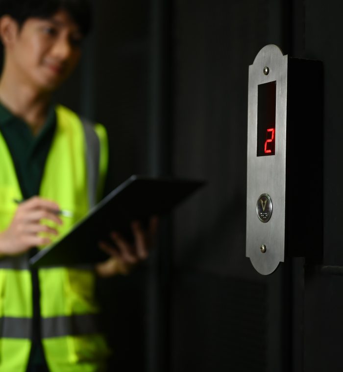 Smiling male worker wearing reflective jackets checking stock and order details in warehouse.